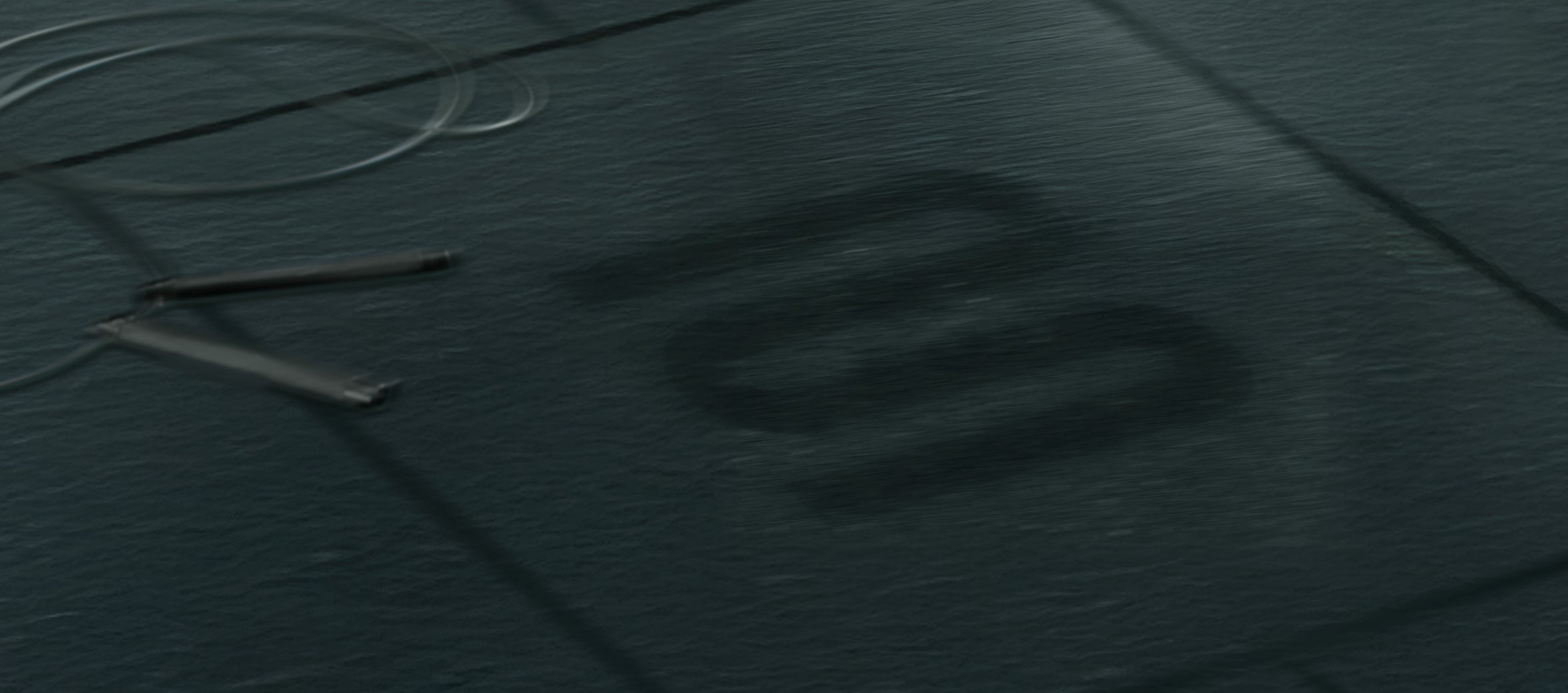 Close-up of a textured dark surface with a brand logo and a jump rope